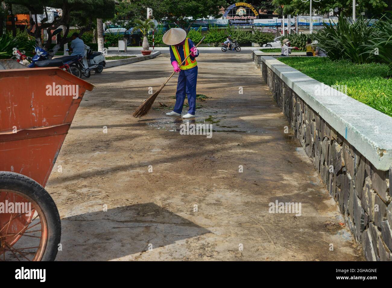 Sweeper worker cleaning city street with broom. Nha Trang, Vietnam: 2020-10-18 Stock Photo