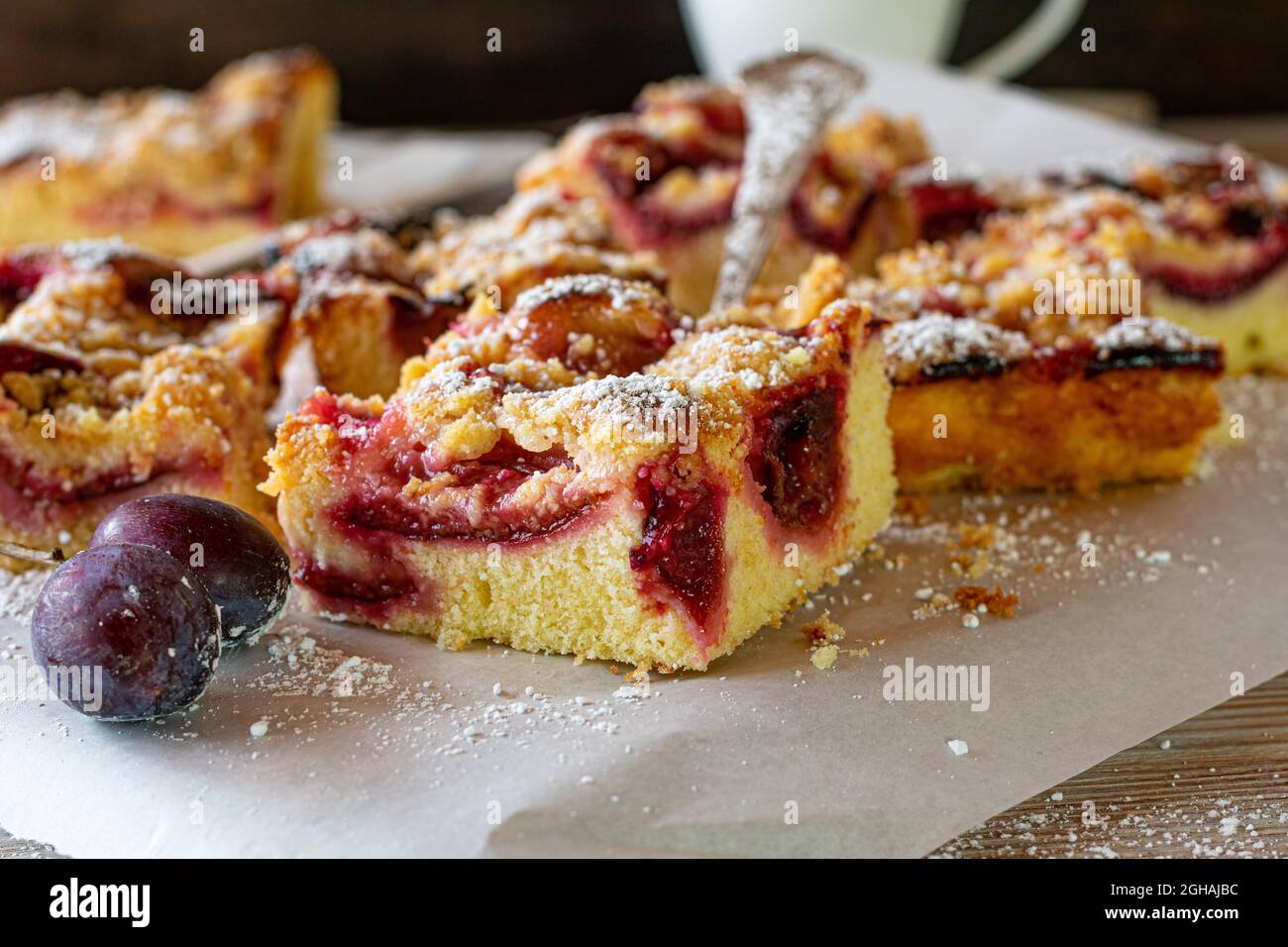 Plum crumble cake sliced on a plate on coffee table Stock Photo