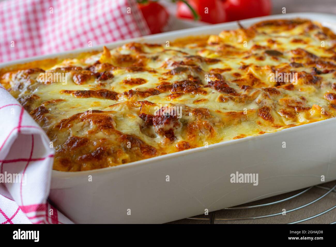 Traditional fresh baked italian pasta casserole with bolognese sauce, bechamel sauce and sliced mozzarella topping in a baking dish Stock Photo