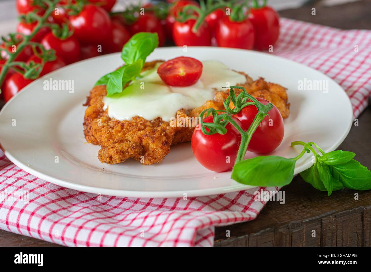 Breaded chicken schnitzel with mozzarella cheese on a plate Stock Photo