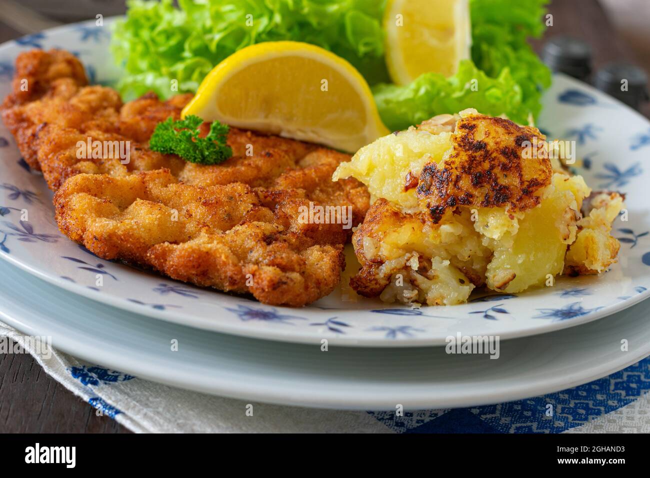 Rustic meat dish with austrian vienna schnitzel and potato schmarrn on a plate Stock Photo