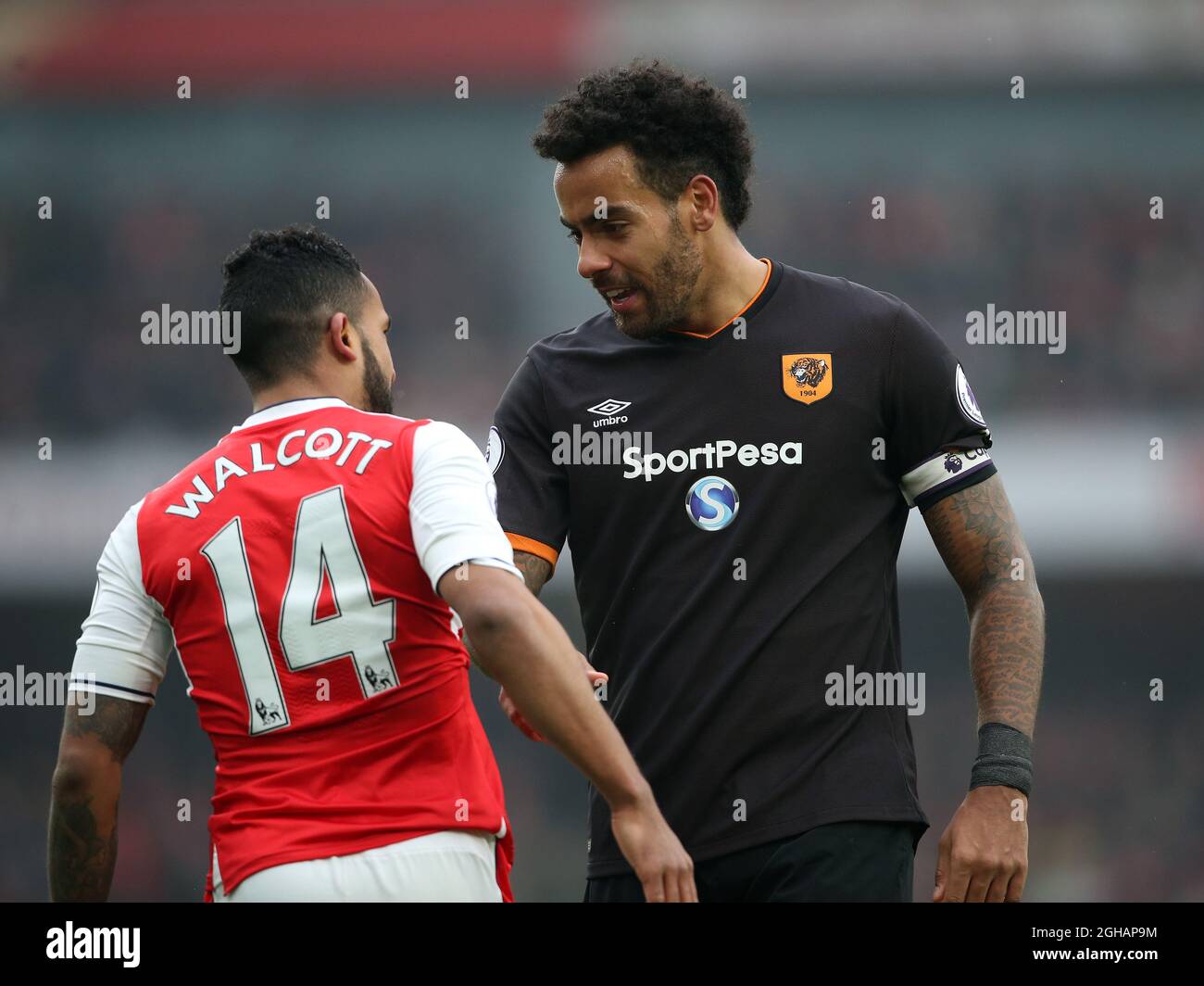 Arsenal's Theo Walcott tussles with Hull City's Tom Huddlestone during