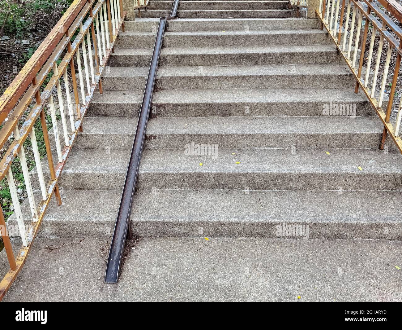 Stair-safe bike ramp along stairs. Comfortable and safe lanes for bicycles  on stairs. Old and rusted steel rails for bicycles up and down for comfort  Stock Photo - Alamy
