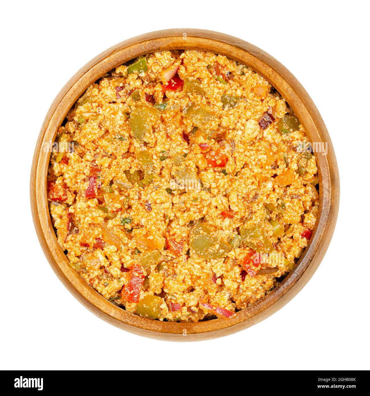 Vegan Liptauer bread spread, in a wooden bowl. Spicy spread, made of crumbled white tofu, red peppers, gherkins, onions and spices. Stock Photo