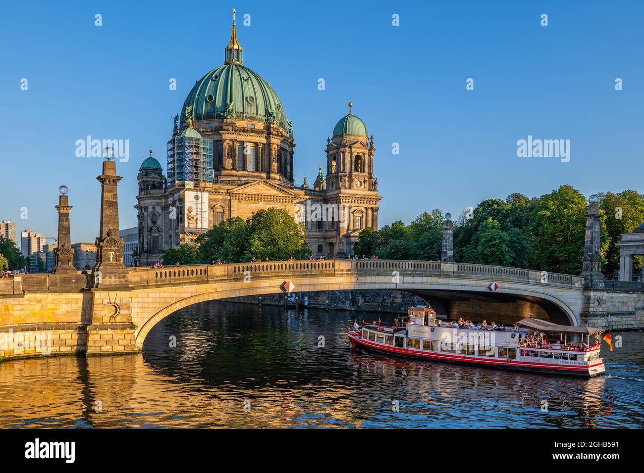 Berlin, Germany - July 30, 2021: Berlin Cathedral (Berliner Dom) and Friedrichs Bridge (Friedrichsbrucke) with tour boat on Spree river at sunset Stock Photo
