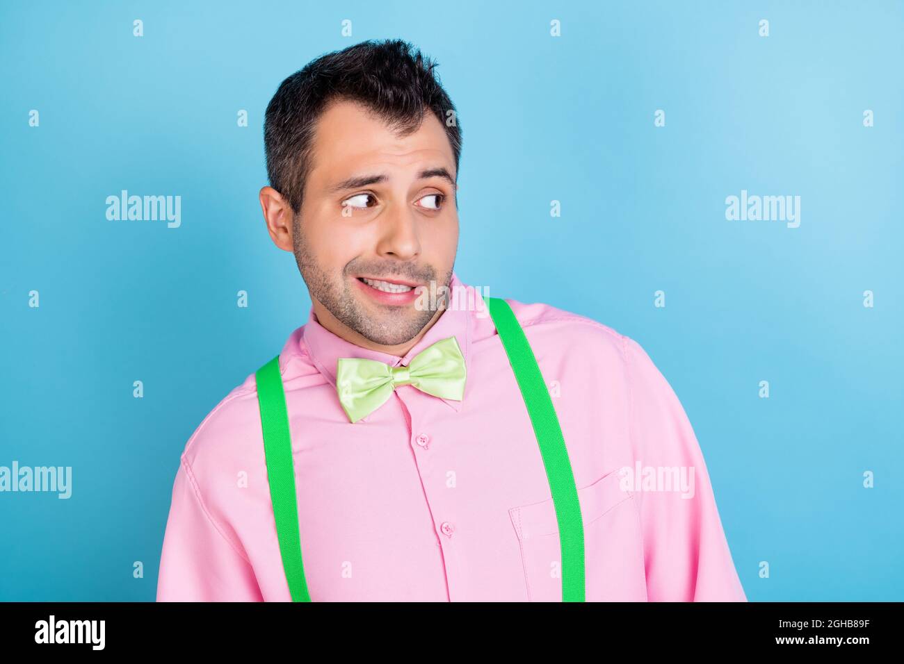 Photo of suspicious distrustful guy look empty space wear green suspenders  shirt bow tie isolated blue color background Stock Photo - Alamy