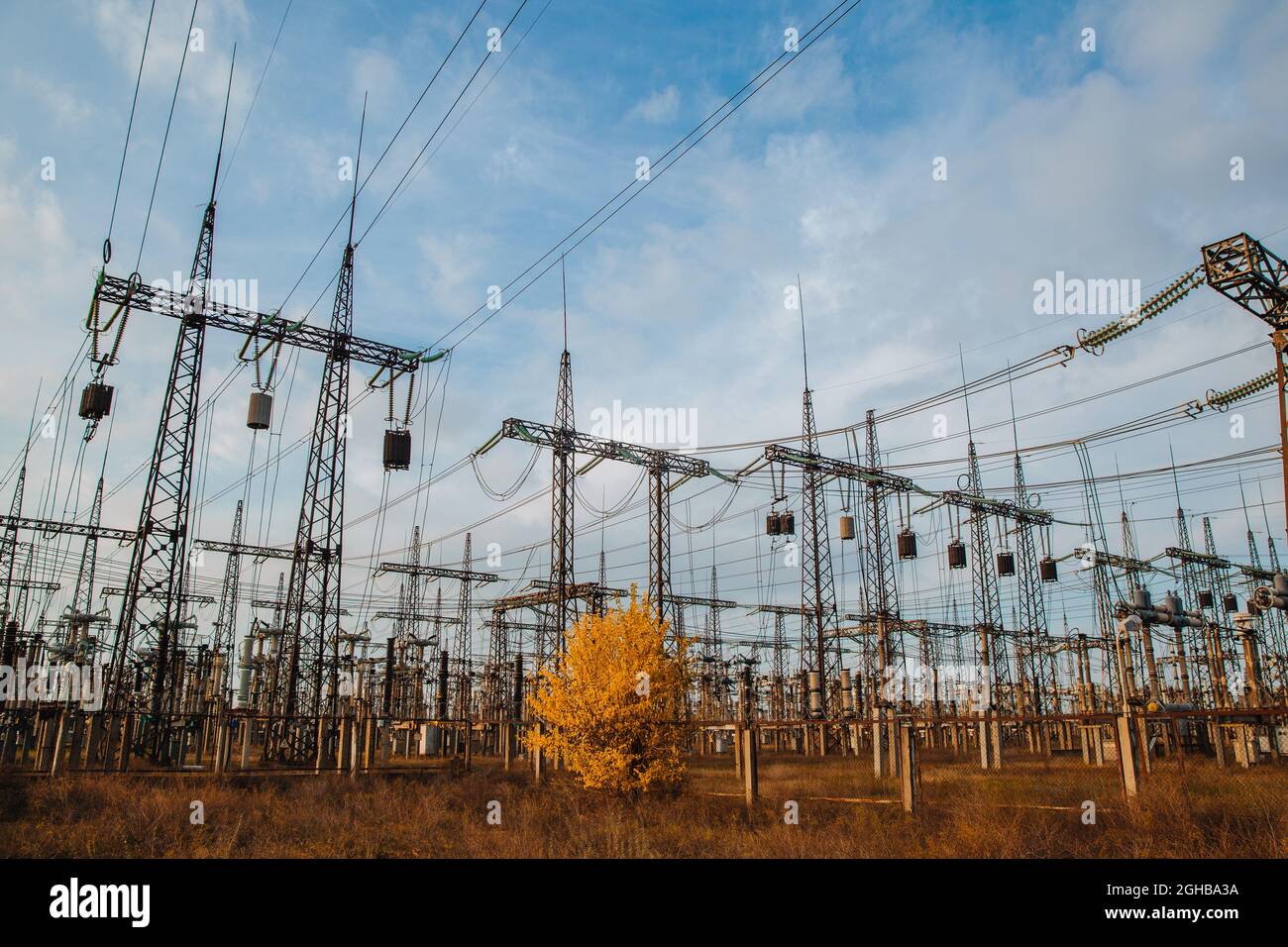 Electrical pylons and high voltage power lines are behind a barbed wire