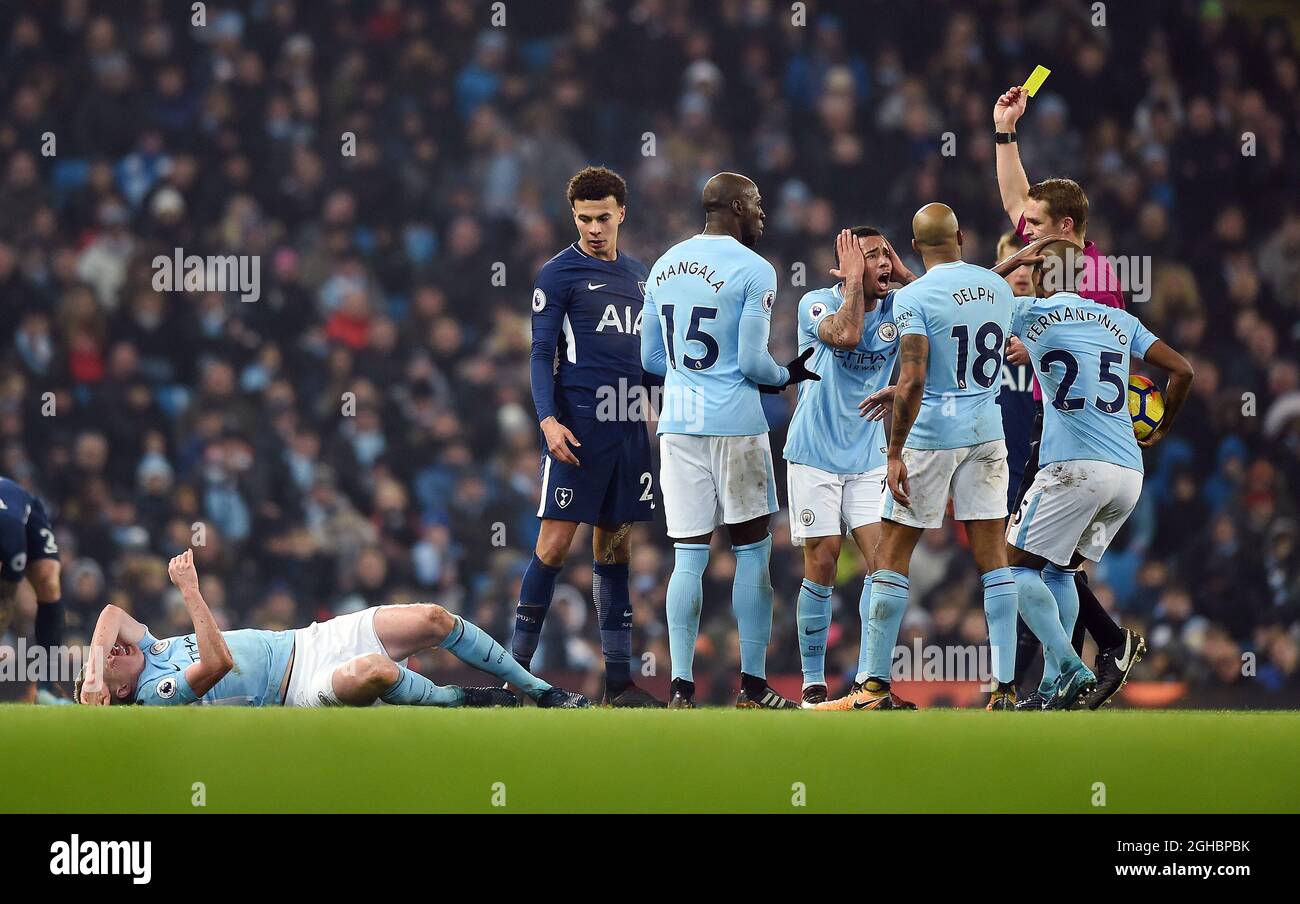 Dele Alli Of Tottenham Hotspur Gets A Yellow Card From Referee Craig Pawson After The Challenge On Kevin De Bruyne Of Manchester City During The Premier League Match At The Etihad Stadium