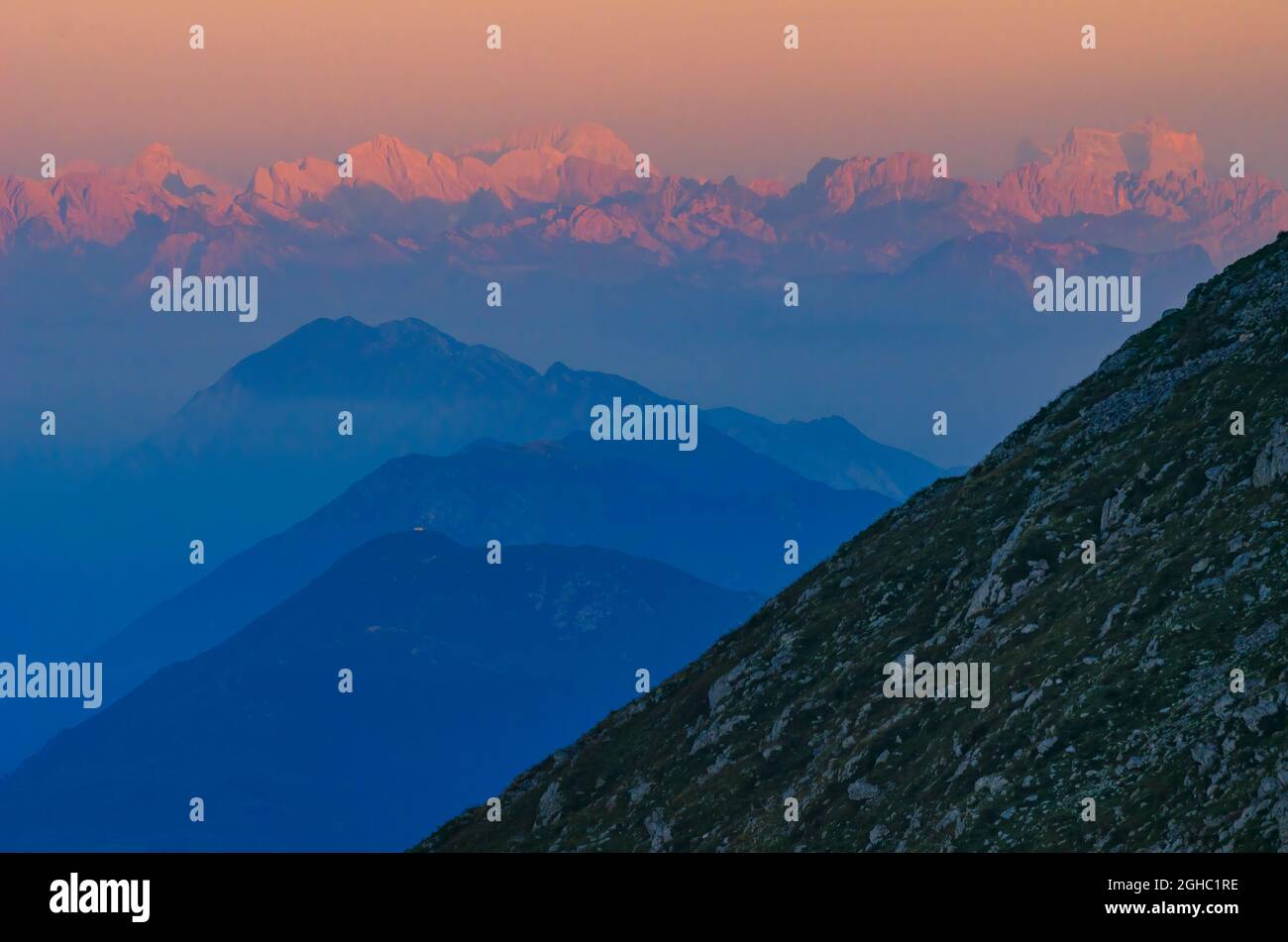 Pink Dolomites mountains illuminated by the first rays of morning sun. View from the Krn mountain, Slovenia Stock Photo
