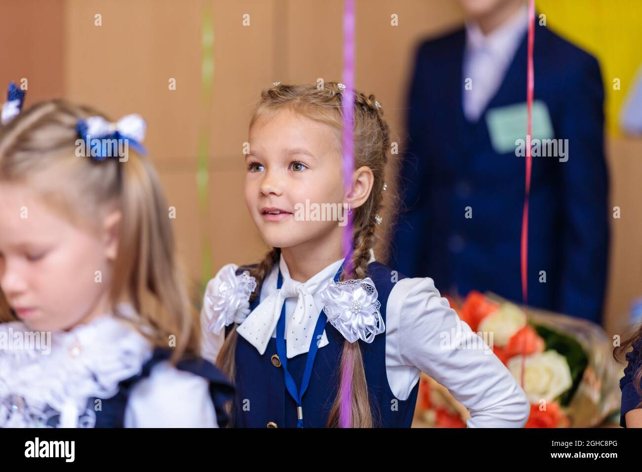 First graders in the classroom perform a warm-up while standing. She is in grade 1 school. Moscow, Russia, September 1, 2021 Stock Photo