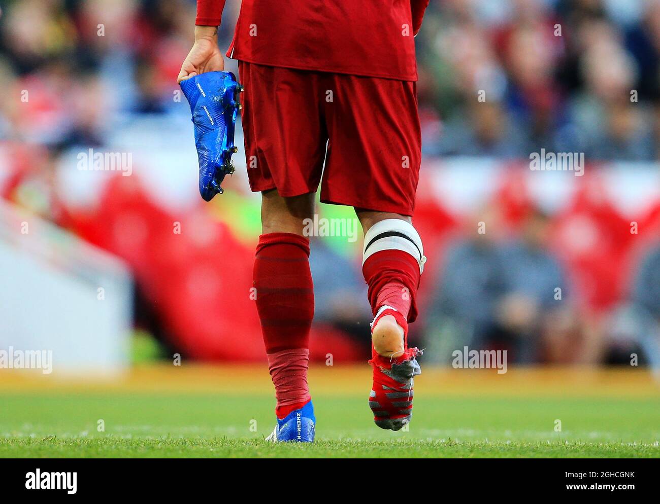 Liverpool's Roberto Firmino carries his boot and shows off a ripped sock  after a collision with Brighton & Hove Albion's Matthew Ryan during the  Premier League match at Anfield Stadium, Liverpool. Picture