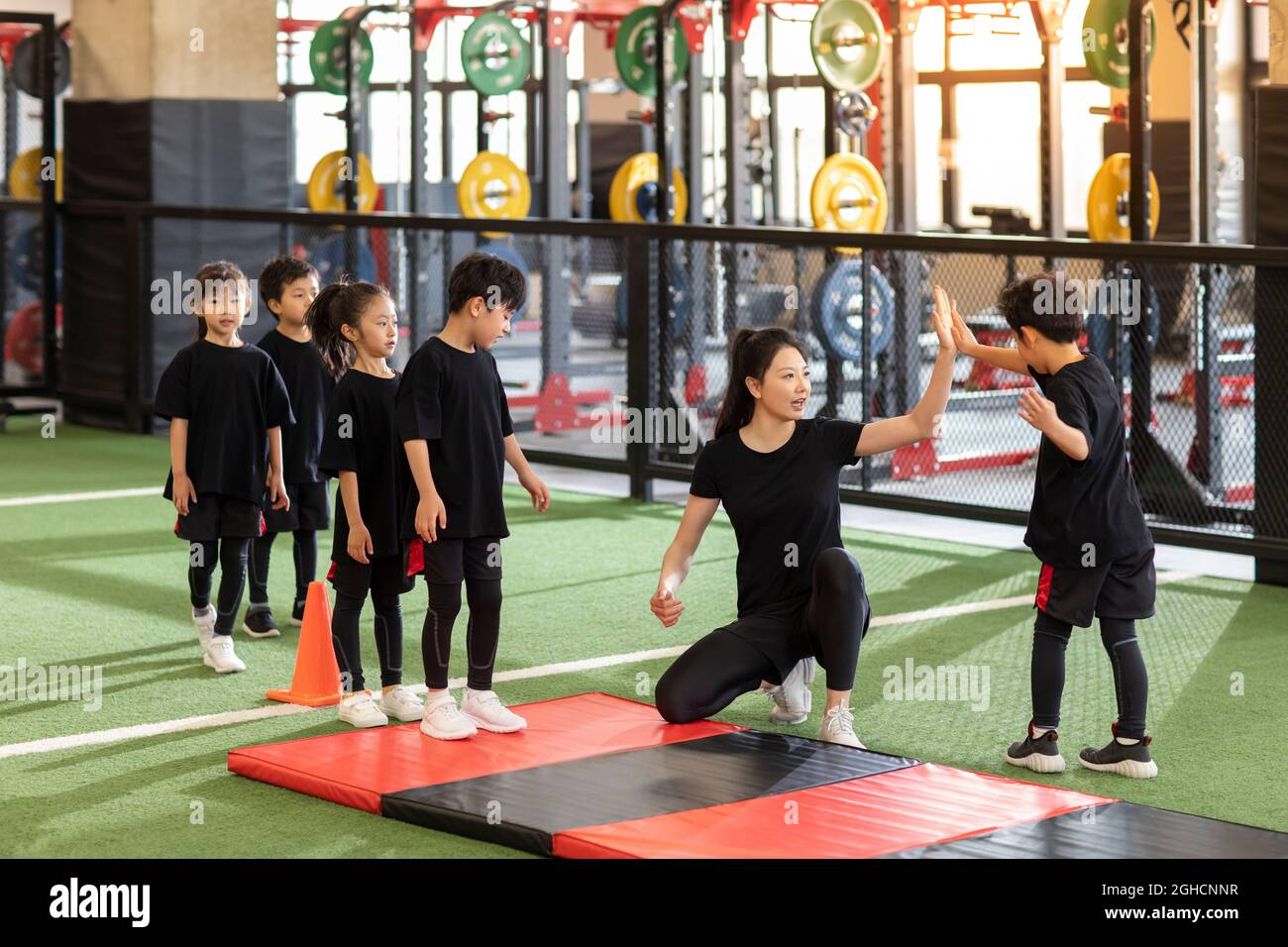 Active children having exercise class with their coach in gym Stock ...