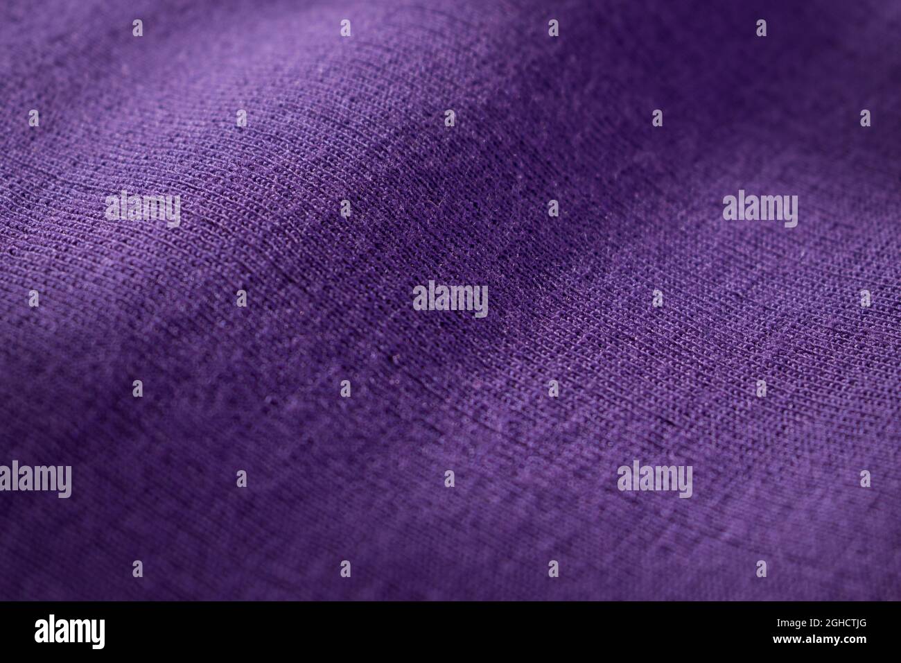 Close up of purple knitted wool texture of a sweater with shadows Stock Photo