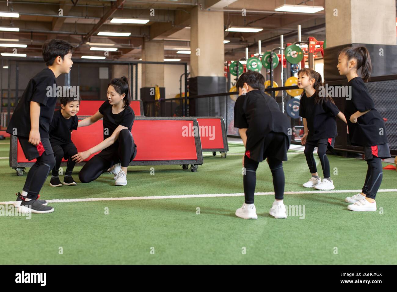 Active children having exercise class with their coach in gym Stock ...