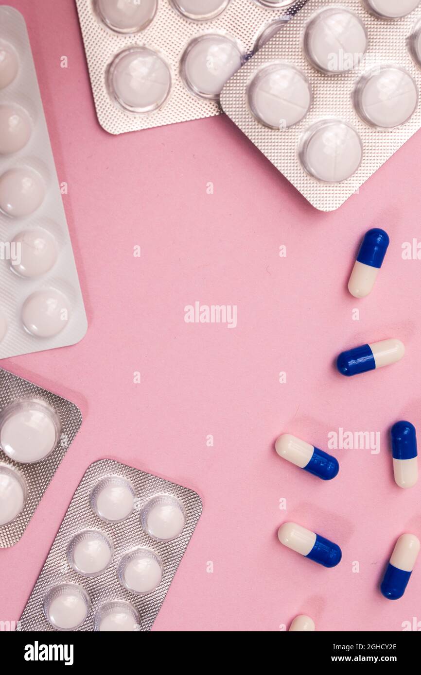 Some different pills and envelope of pills on a pink background with copy space Stock Photo