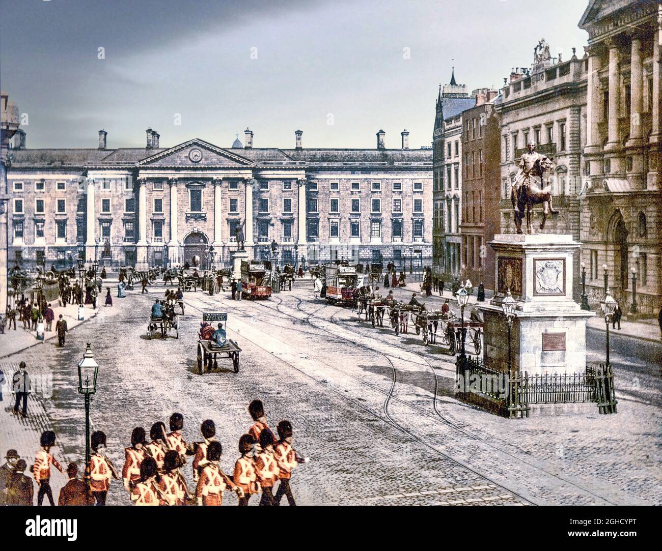 An early 20th century photograph of Trinity College (University) in College Green in Dublin City centre, Ireland, with soldiers, horse drawn vehicles and the newly introduced electric trams. Stock Photo