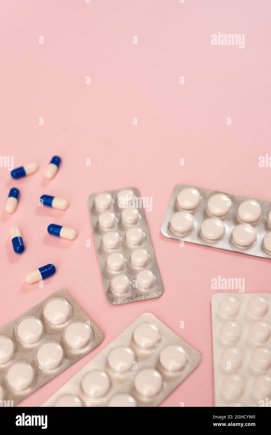Some different pills and envelope of pills on a pink background with copy space Stock Photo
