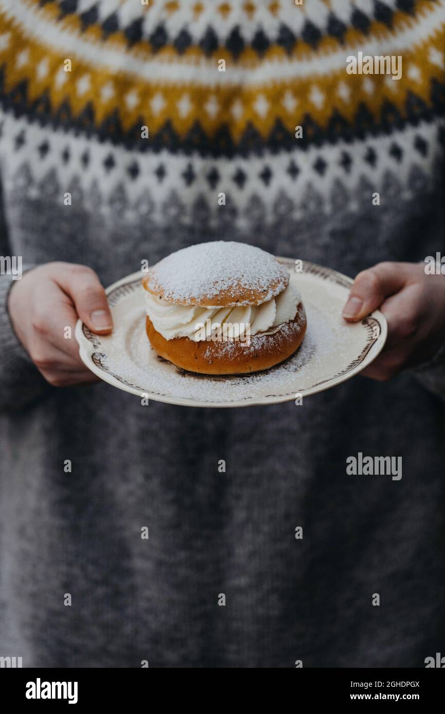 Boy holding the Swedish pastry semla, on a plate Stock Photo