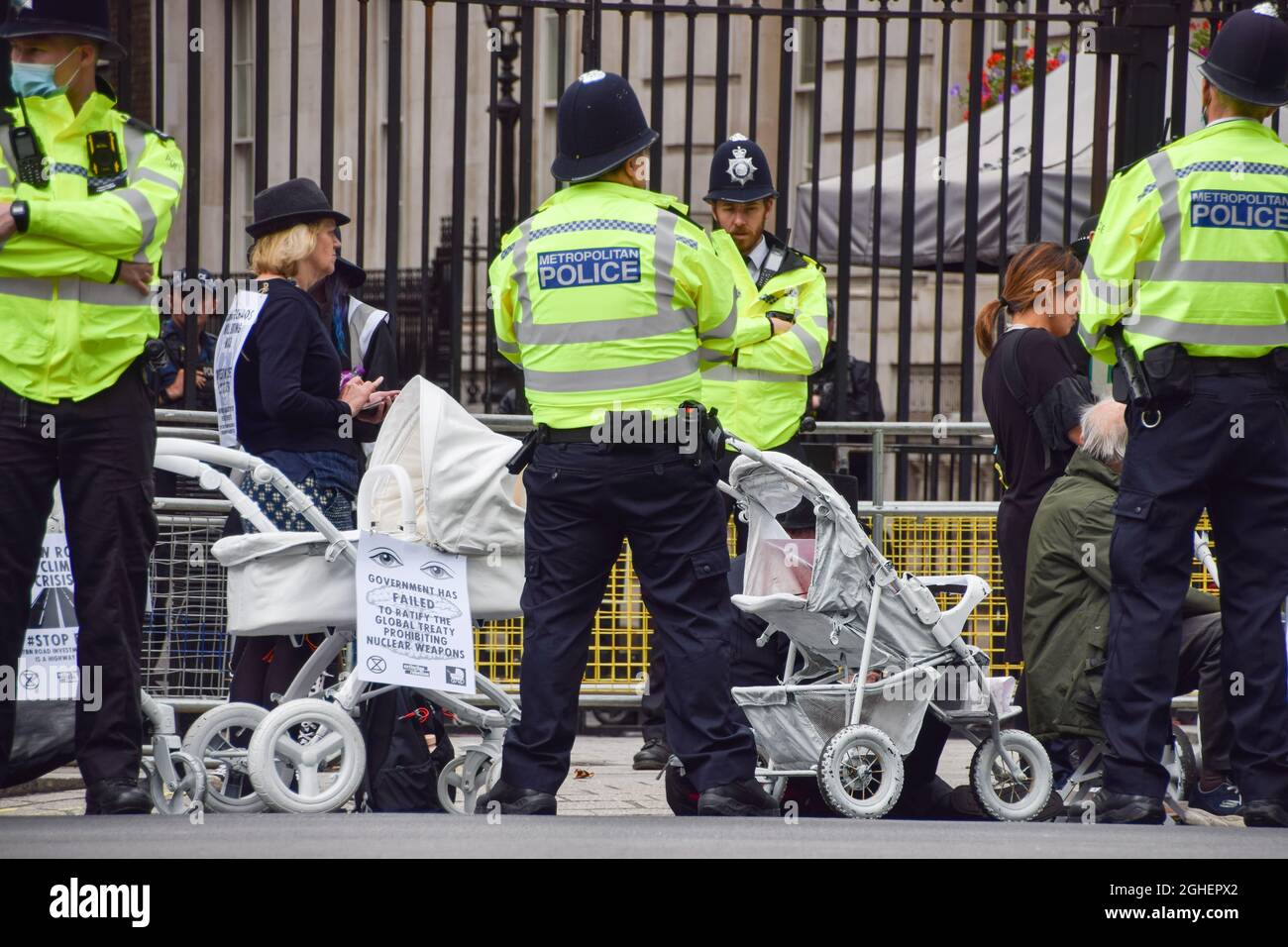 London, United Kingdom. 31st August 2021. Police observe protesters with prams outside Downing Street. Extinction Rebellion protesters dressed in black marched with prams in Westminster as part of their two-week Impossible Rebellion campaign. Stock Photo