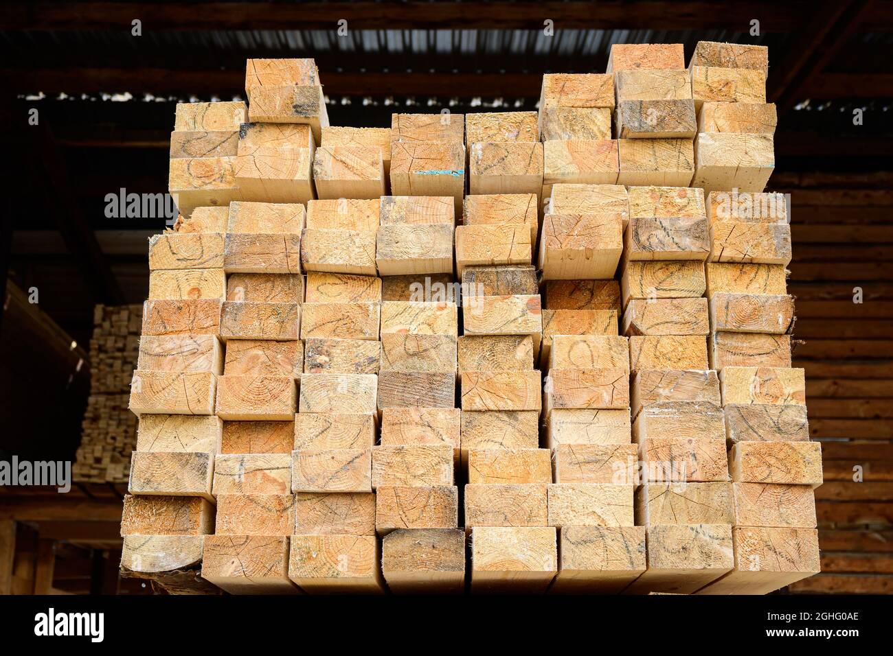 Piles of wooden planks at the sawmill for the manufacture of cladding. Warehouse of boards in the open air for the construction of houses. Timber in s Stock Photo