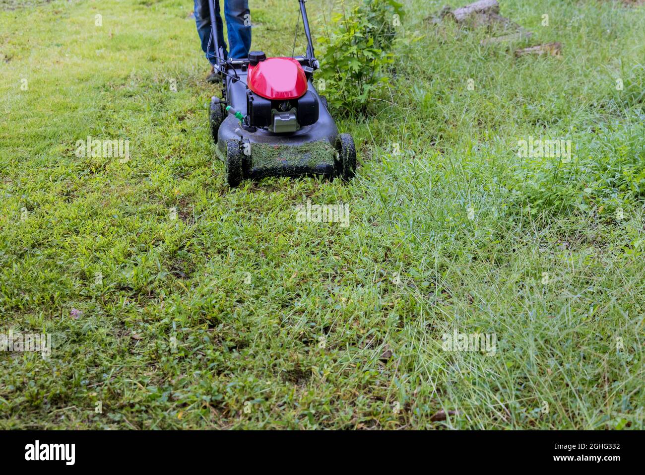 Utility worker in lawn mower gardener cutting the grass ride-on lawnmower Stock Photo