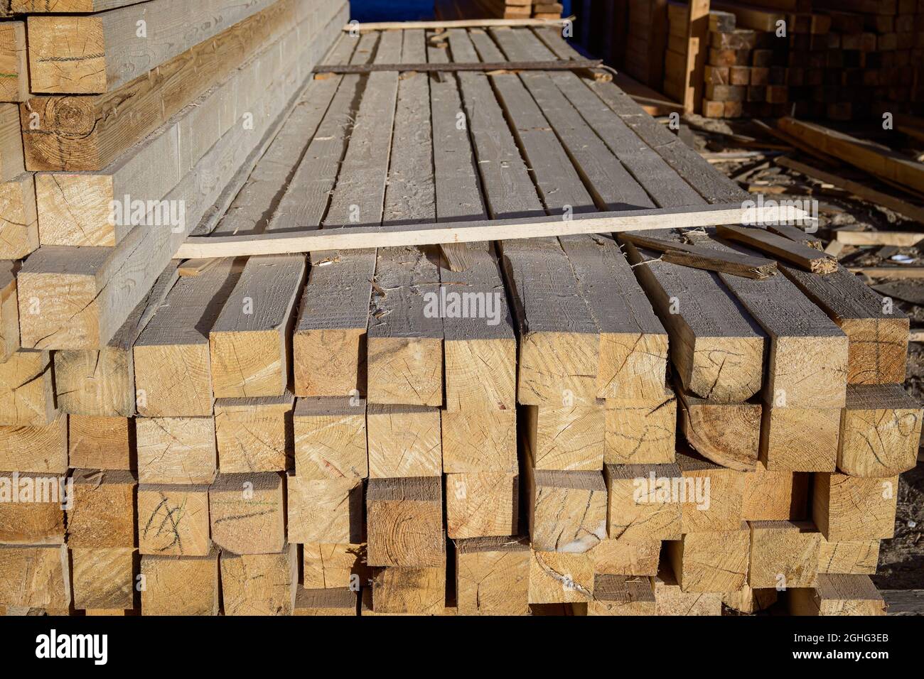 Piles of wooden planks at the sawmill for the manufacture of cladding. Warehouse of boards in the open air for the construction of houses. Timber in s Stock Photo