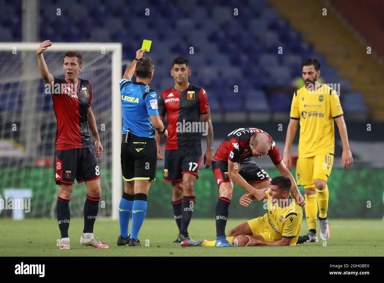 Matteo Pessina of Hellas Verona writhes in agony after dislocating his patella as Cristian Romero of Genoa CFC is shown a yellow card by referee Massimiliano Irrati for the challenge during the Serie A match at Luigi Ferraris, Genoa. Picture date: 2nd August 2020. Picture credit should read: Jonathan Moscrop/Sportimage via PA Images Stock Photo