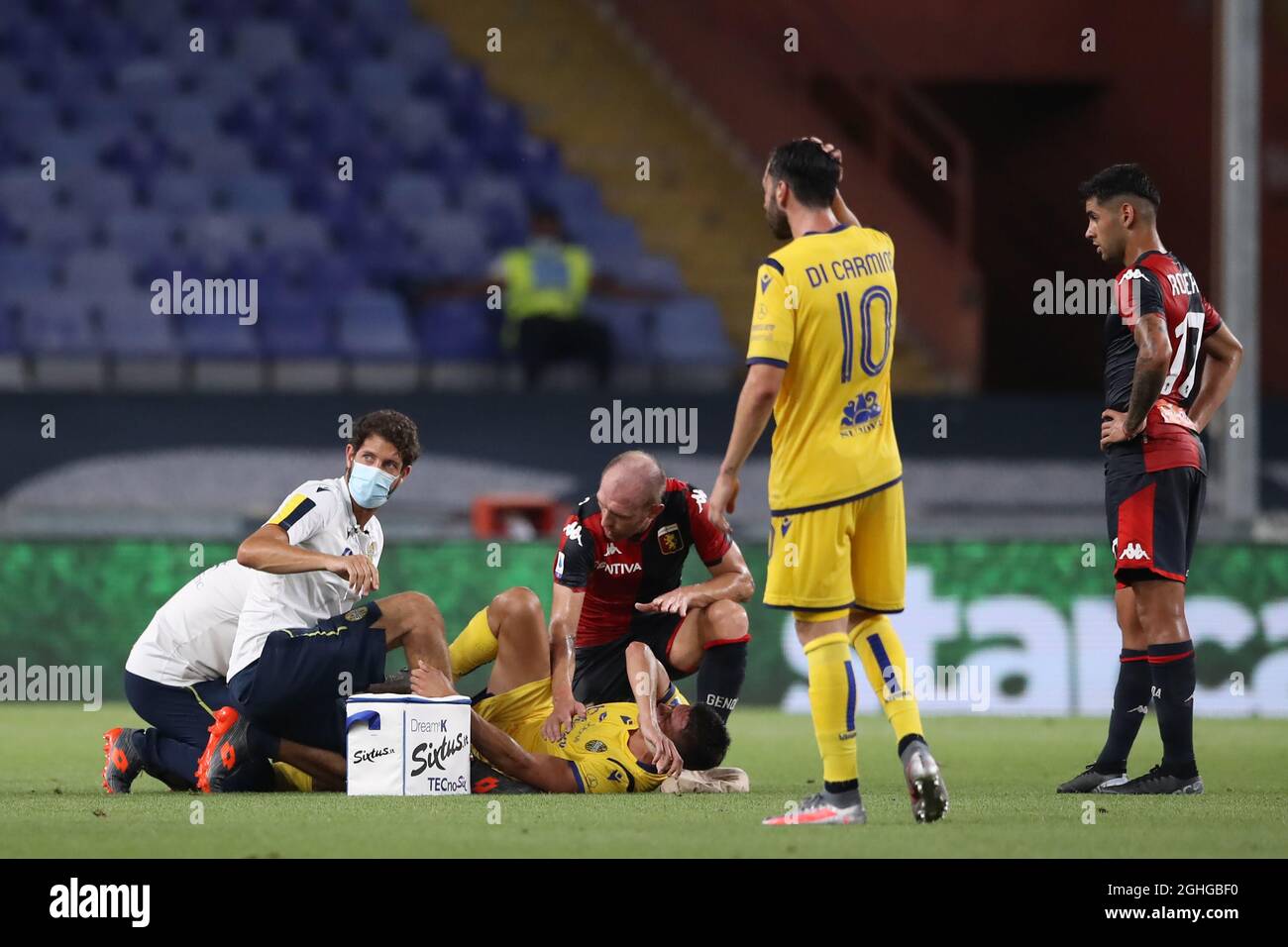 Matteo Pessina of Hellas Verona receives medical attention after dislocating his patella in a challenge with Cristian Romero of Genoa CFC whom was subsequently shown a yellow card by referee Massimiliano Irrati during the Serie A match at Luigi Ferraris, Genoa. Picture date: 2nd August 2020. Picture credit should read: Jonathan Moscrop/Sportimage via PA Images Stock Photo