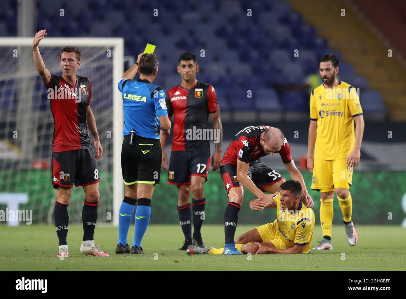 Matteo Pessina of Hellas Verona writhes in agony after dislocating his patella as Cristian Romero of Genoa CFC is shown a yellow card by referee Massimiliano Irrati for the challenge during the Serie A match at Luigi Ferraris, Genoa. Picture date: 2nd August 2020. Picture credit should read: Jonathan Moscrop/Sportimage via PA Images Stock Photo