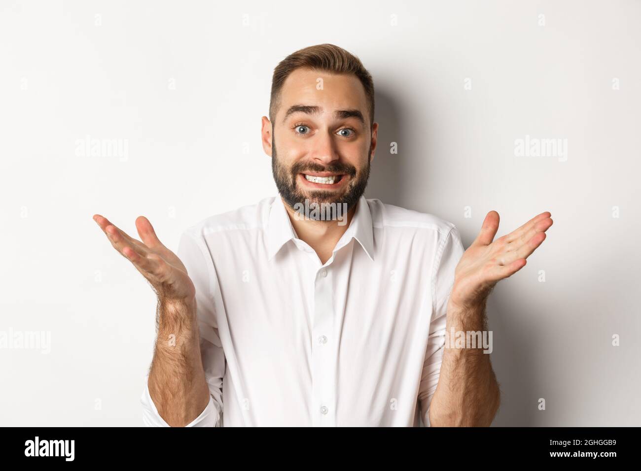 Close-up of awkward manager shrugging and smiling with sorry look ...
