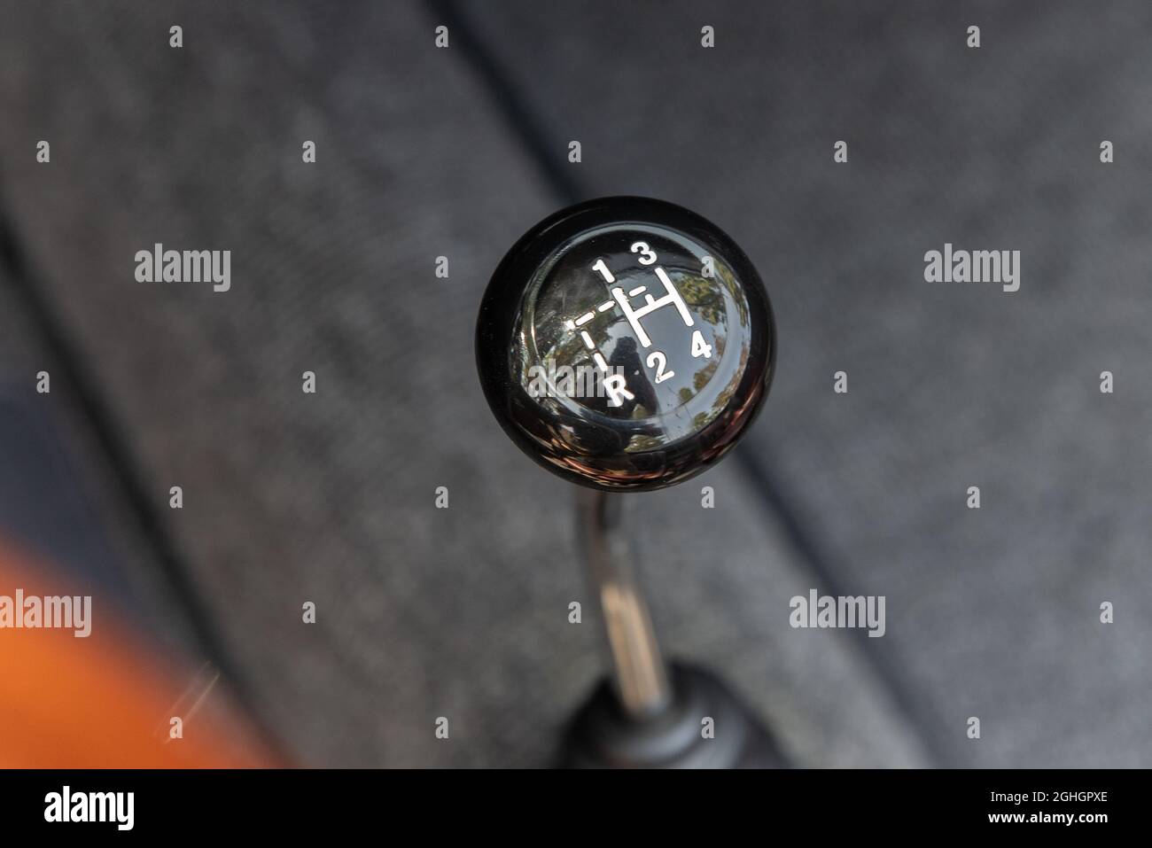 Vintage knob of classic sports car shows the 4 gears and reverse of a manual transmission stick shift automobile. Stock Photo