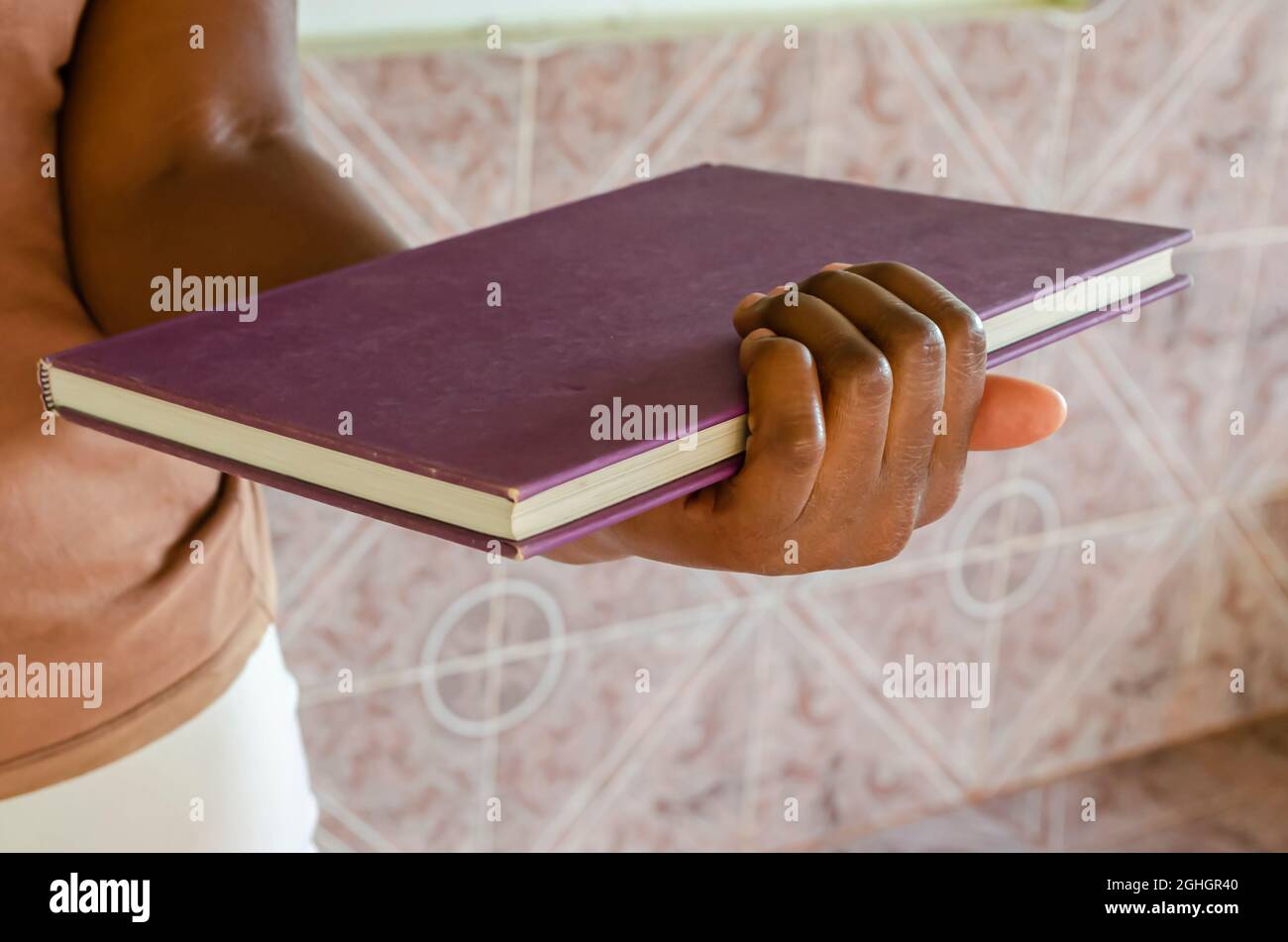 Holding A Closed Bound Book Stock Photo