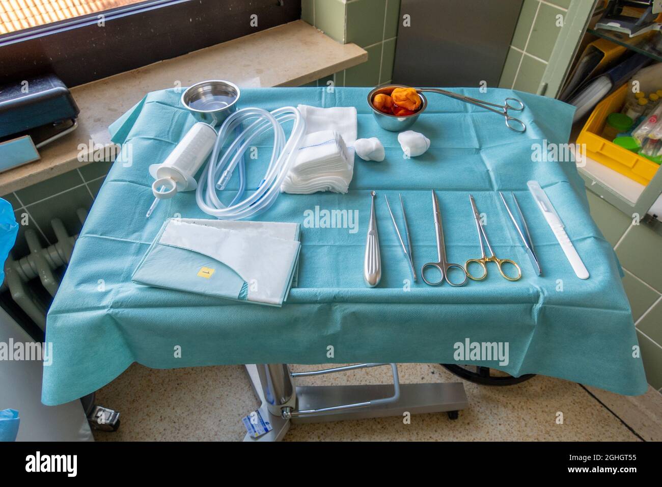 on an instrument table in an operating room lie the instruments for a ...