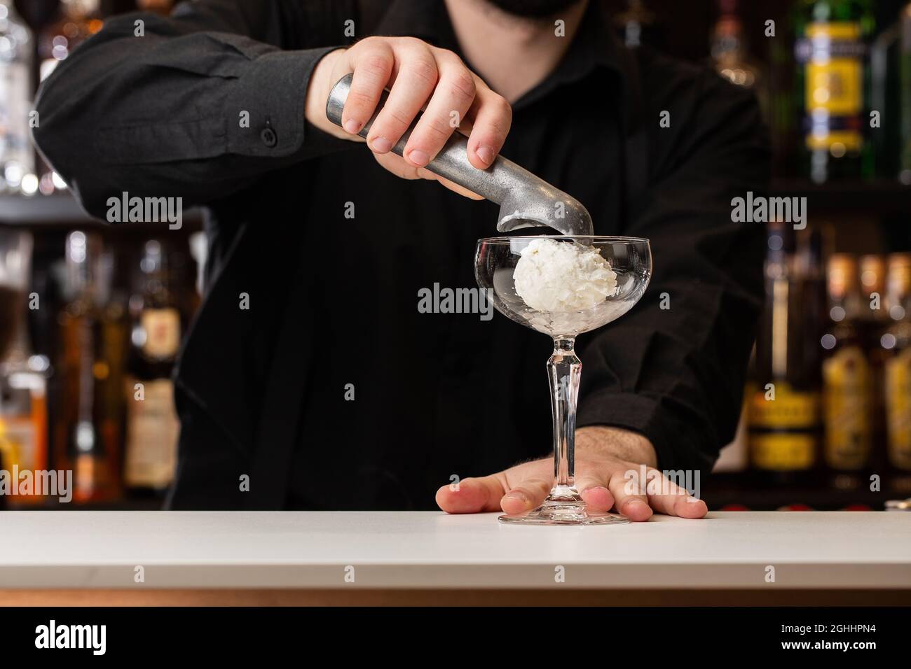 Bartender Pours Red Liquid From Jigger Into Mixing Cup Stock Photo