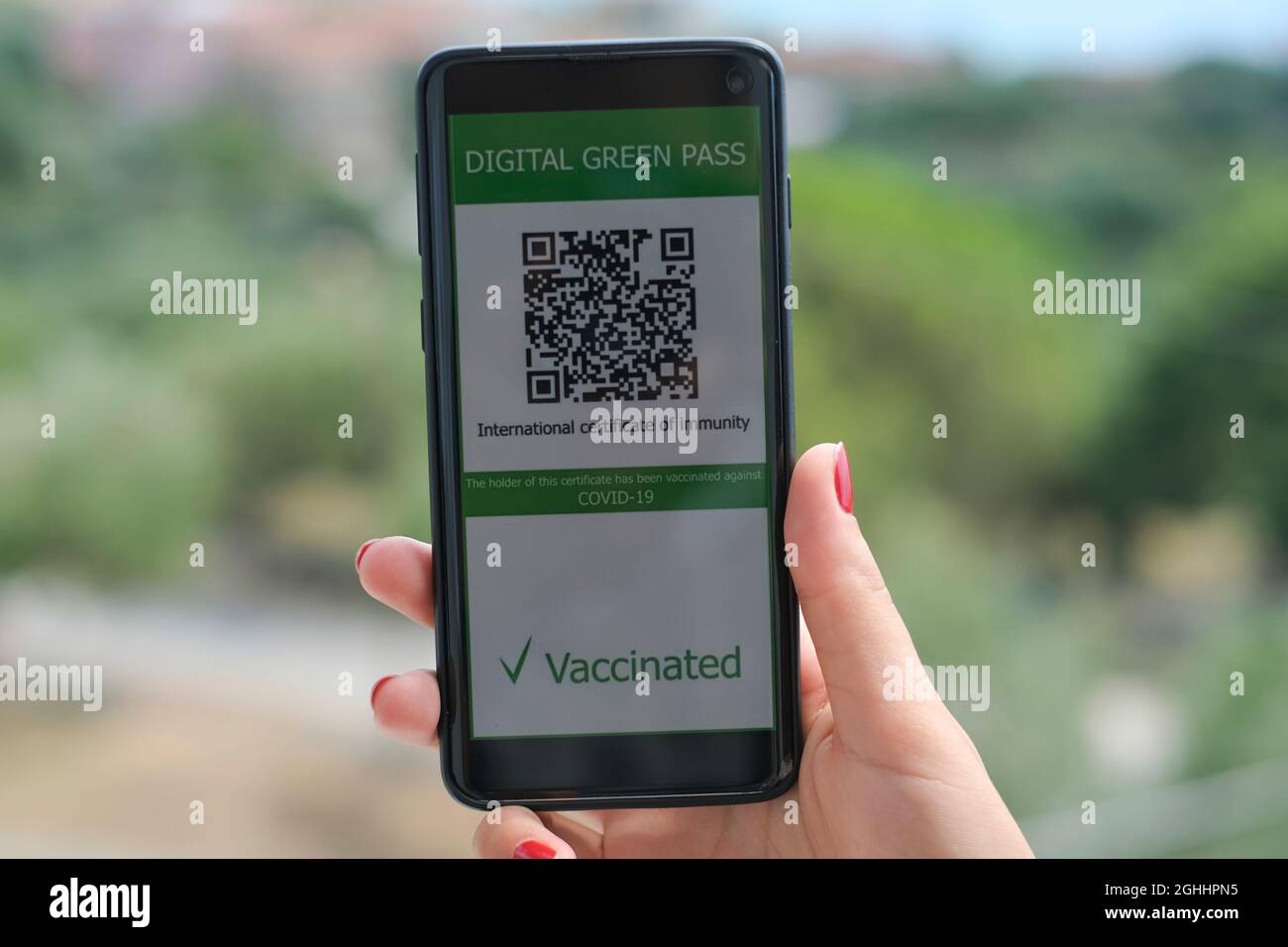Woman hold covid19 vaccine qr code green pass certificate on a smartphone,tech Stock Photo