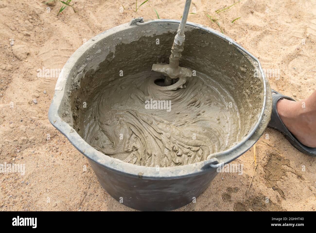 Mixing cement mortar in a bucket with an electric construction drill