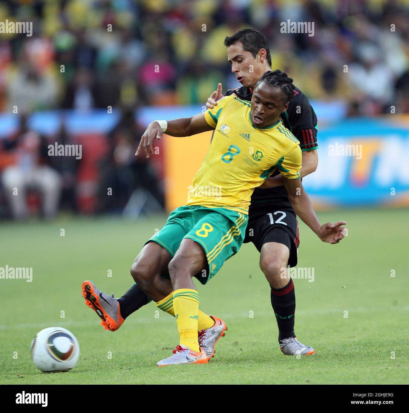 South Africa's Siphiwe Tsahabalala tussles with Mexico's Paul Aguilar. Stock Photo