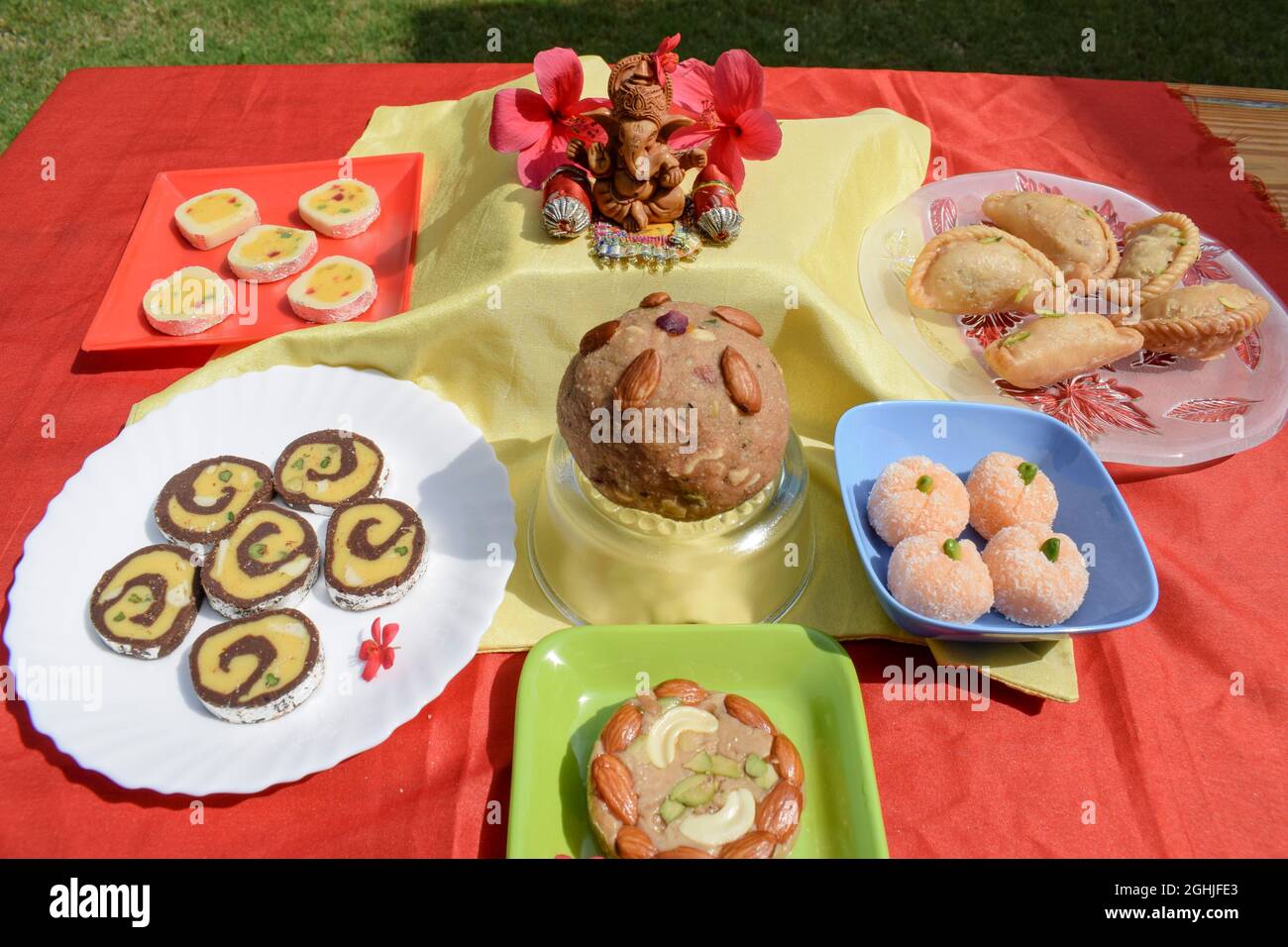 Selective focus of Lord Ganesha with Variety of assorted Indian sweets made for Prashad and offered to lord Ganesha during Festivals like Ganesh chatu Stock Photo