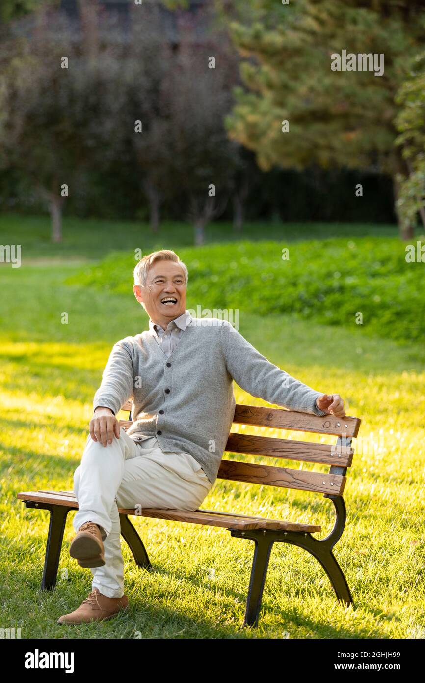 Cheerful senior man sitting on park bench Stock Photo - Alamy