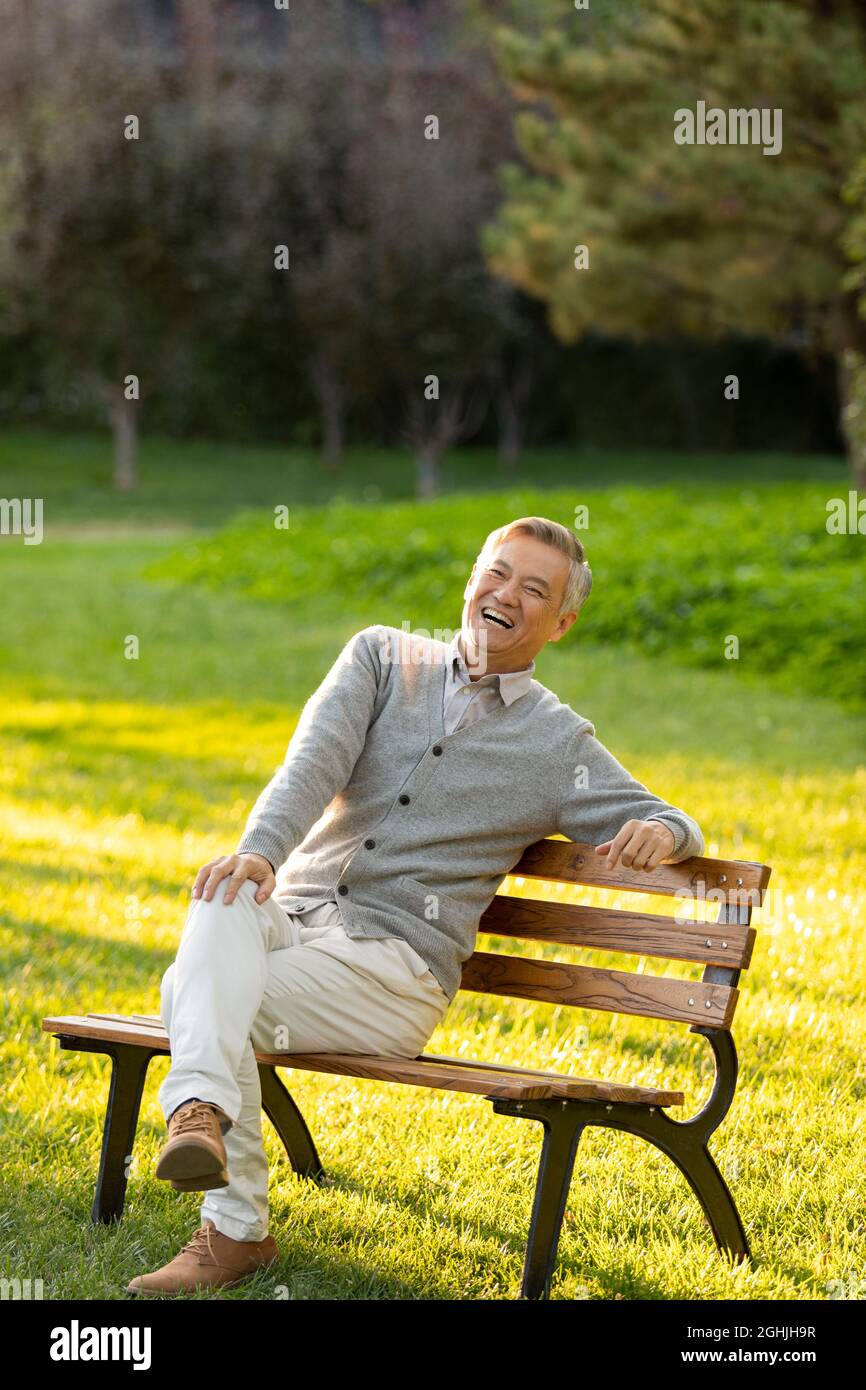 Cheerful senior man sitting on park bench Stock Photo - Alamy