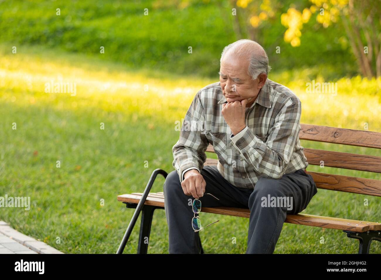 Lonely senior man sitting on park bench Stock Photo - Alamy