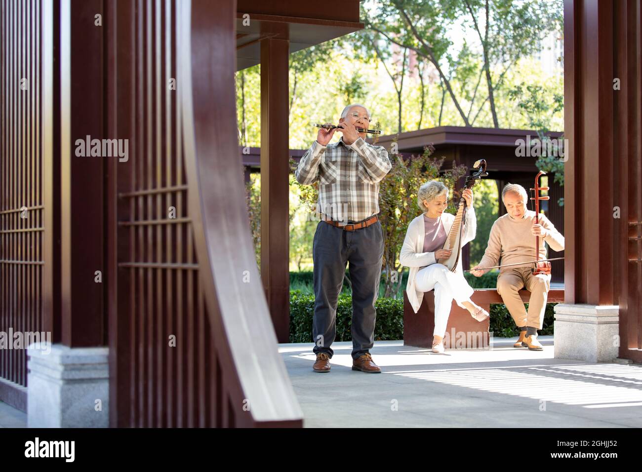Cheerful senior adult playing traditional musical instruments Stock