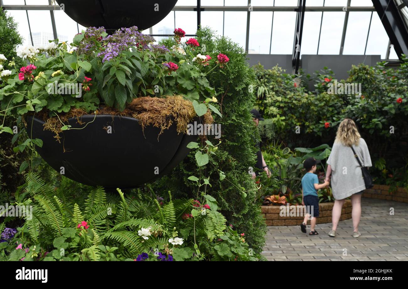 A woman and child look over a display in the Muttart Conservatory