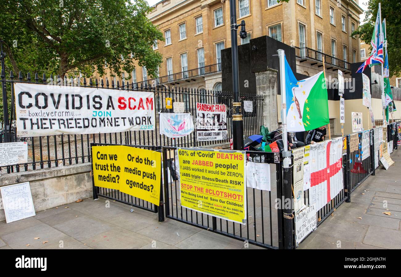 Anti-vax (anti-vaccination) posters, banners and placards in fenced-off area on Whitehall Stock Photo