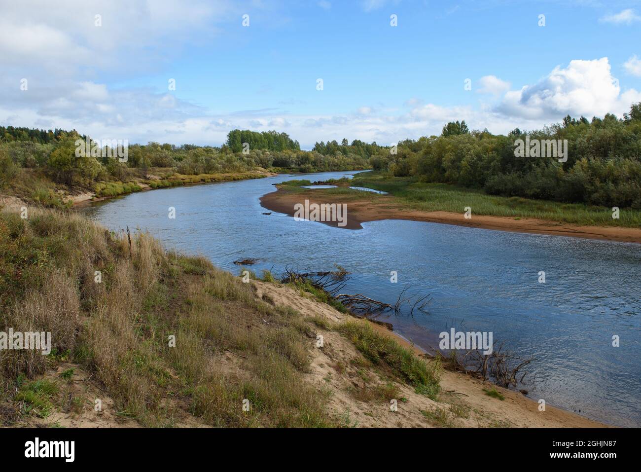 A picturesque river bank in early autumn with grass on the bank ...