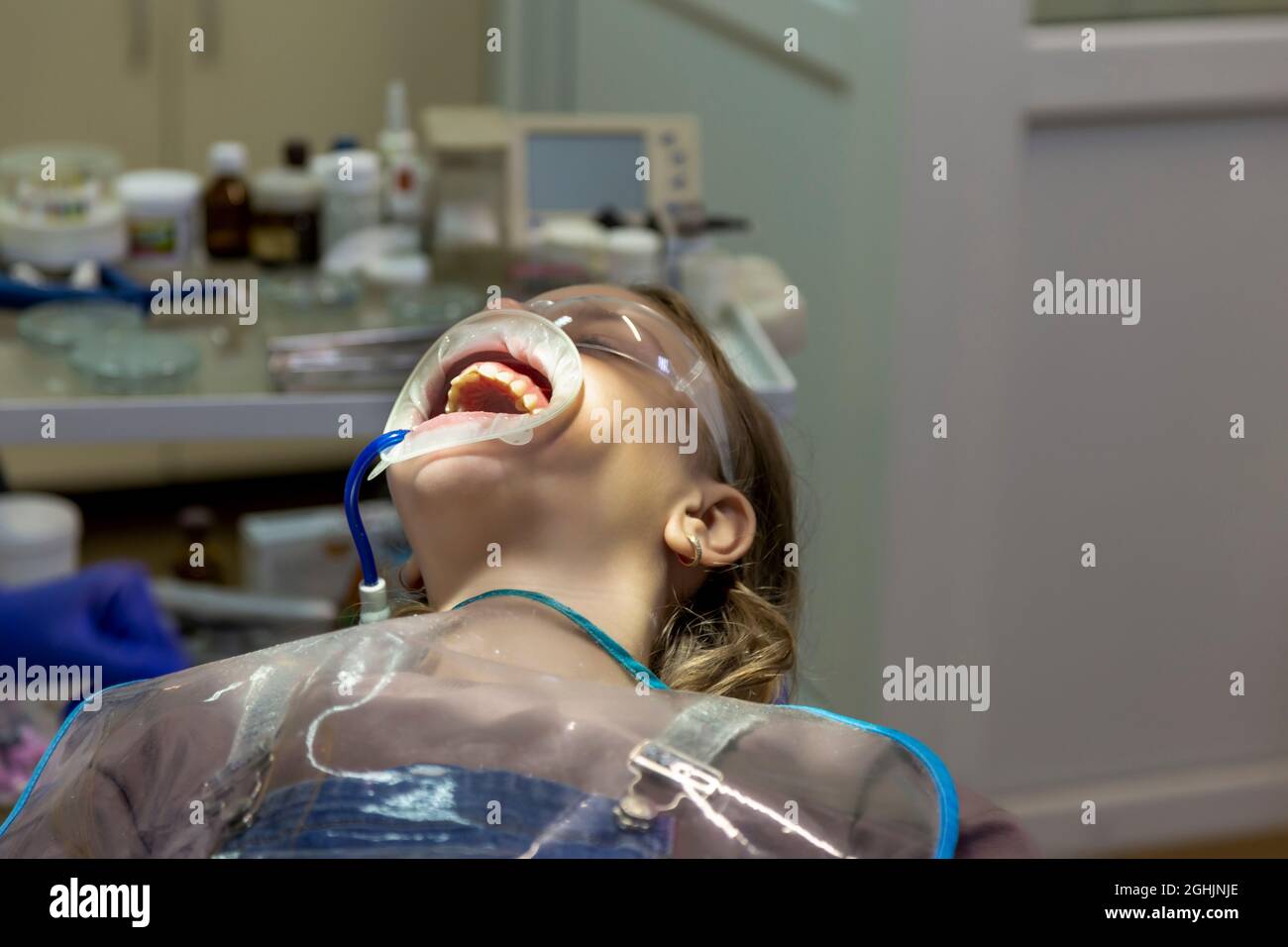 open mouth of a little girl at the dentist's appointment. The girl with an  open mouth sits in a dentist's chair Stock Photo - Alamy