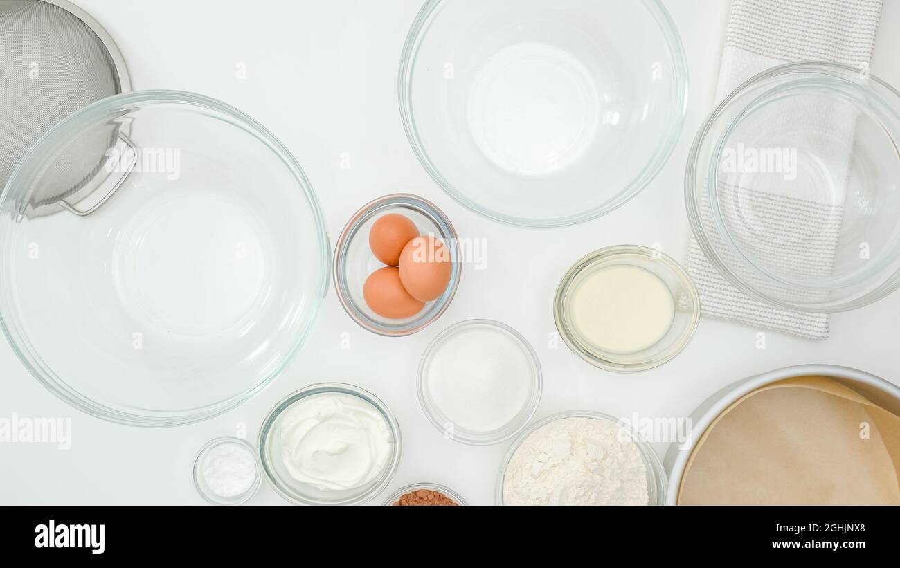 Ingredients and dishes for making  cake close up on kitchen table, view from above. Step by step chocolate cake recipe, white kitchen table background Stock Photo