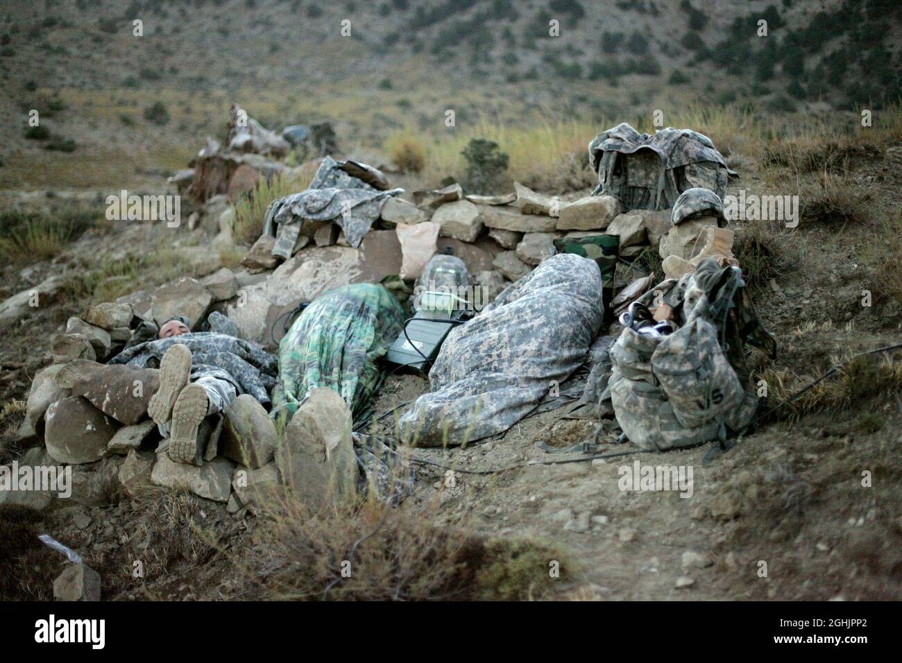 U.S. Army Soldiers sleep in a hasty fighting position on a cold morning after a night patrol in the mountains near Sar Howza, Paktika province, Afghanistan, Sept. 4. The Soldiers are deployed with Bulldog Troop, 1st Squadron, 40th Cavalry Regiment. Stock Photo