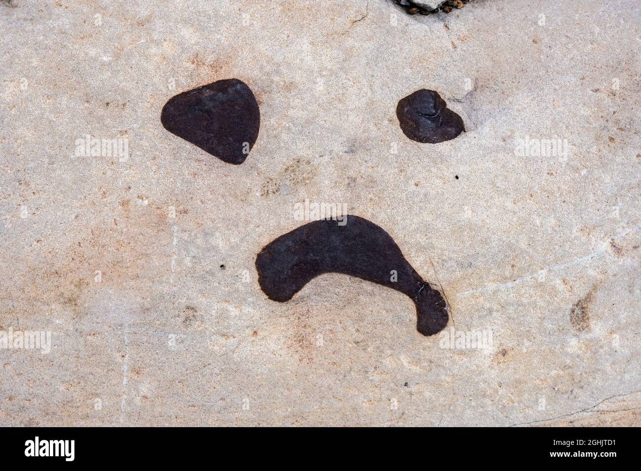Markings On Stone In The Shape Of A Sad Face Emoji Stock Photo Alamy