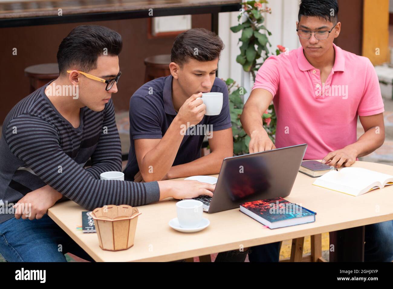 Three young entrepreneurs have coffee in the open air while doing their